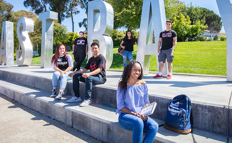 Several students stand in front of 鶹AV Letters